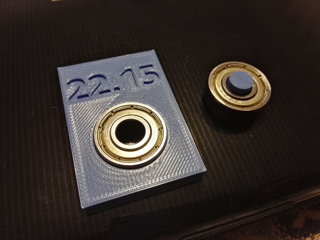 Small printed sample marked 22.15 with a metal bearing fitted into its pocket