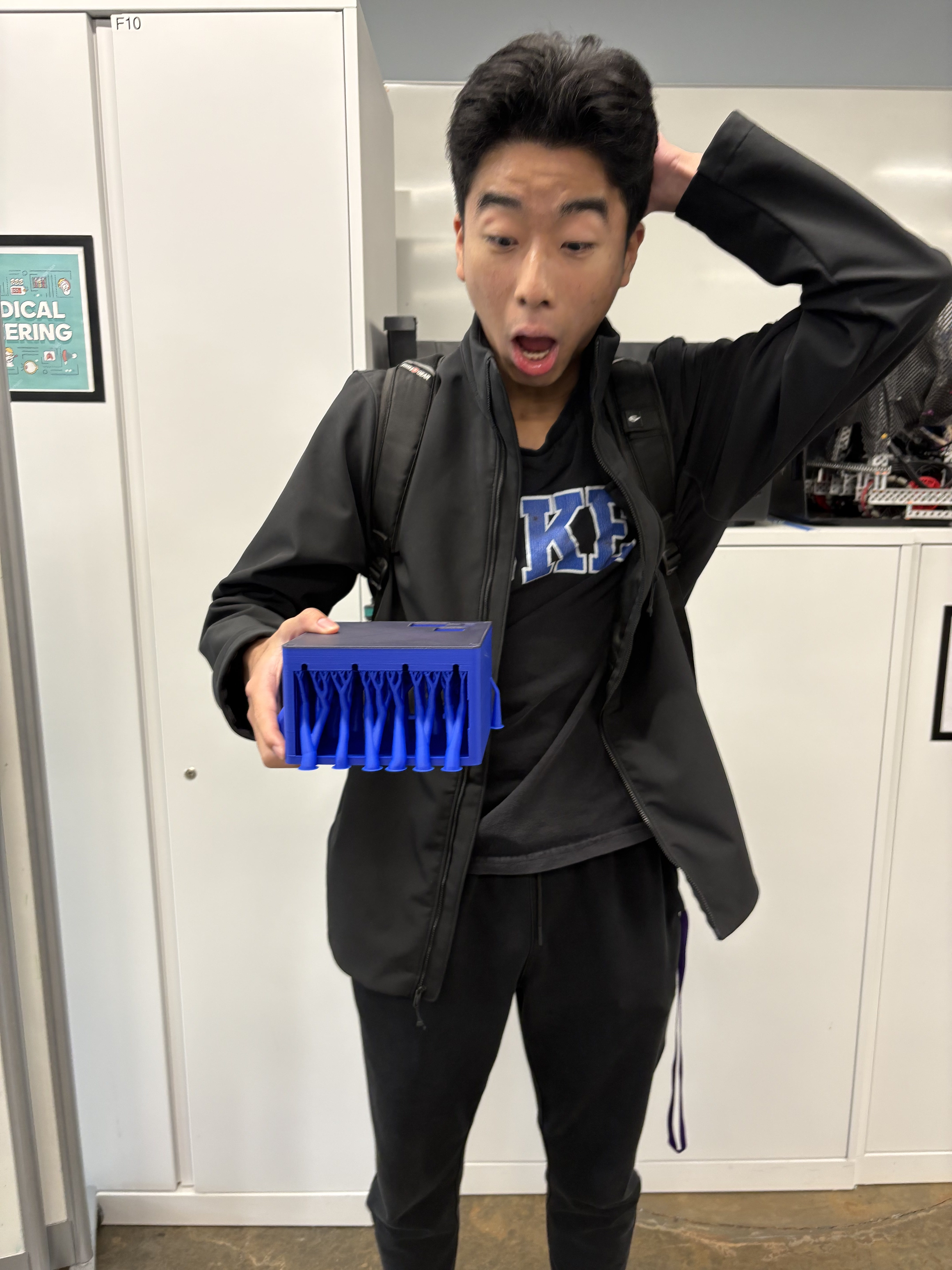 Person holding a blue printed part with extensive tree supports underneath